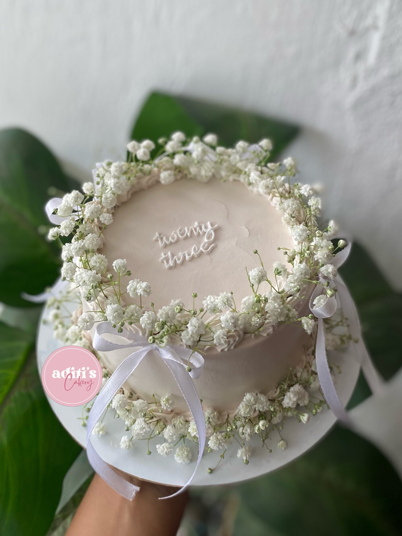 White floral wreath cake with ribbon bows
